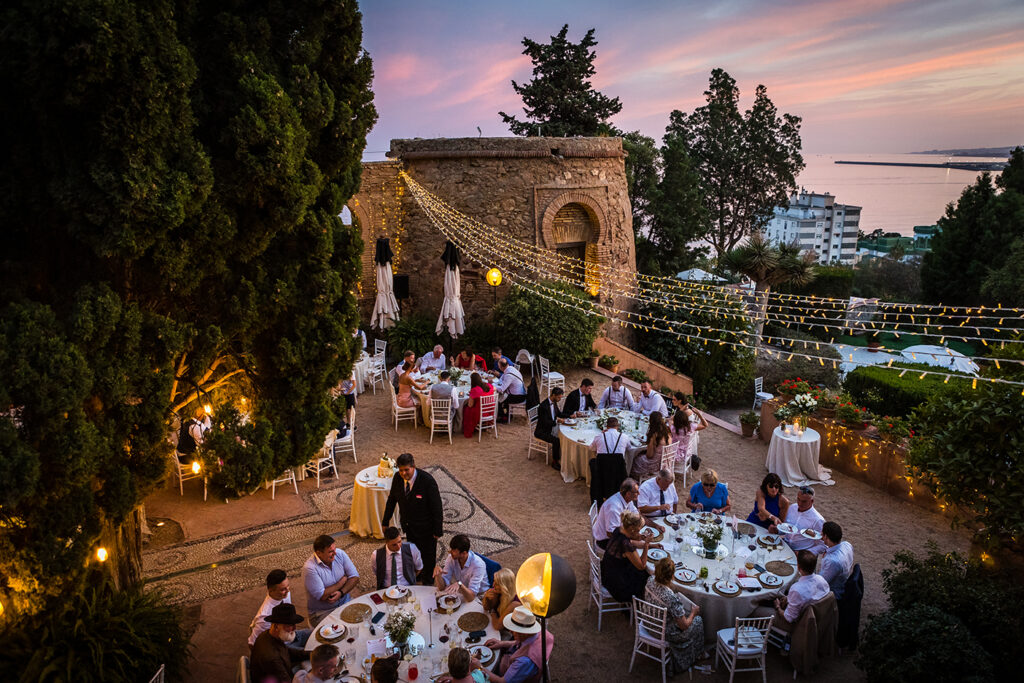 the terraces and gardens of Castillo Santa Catalina in Malaga at dusk.